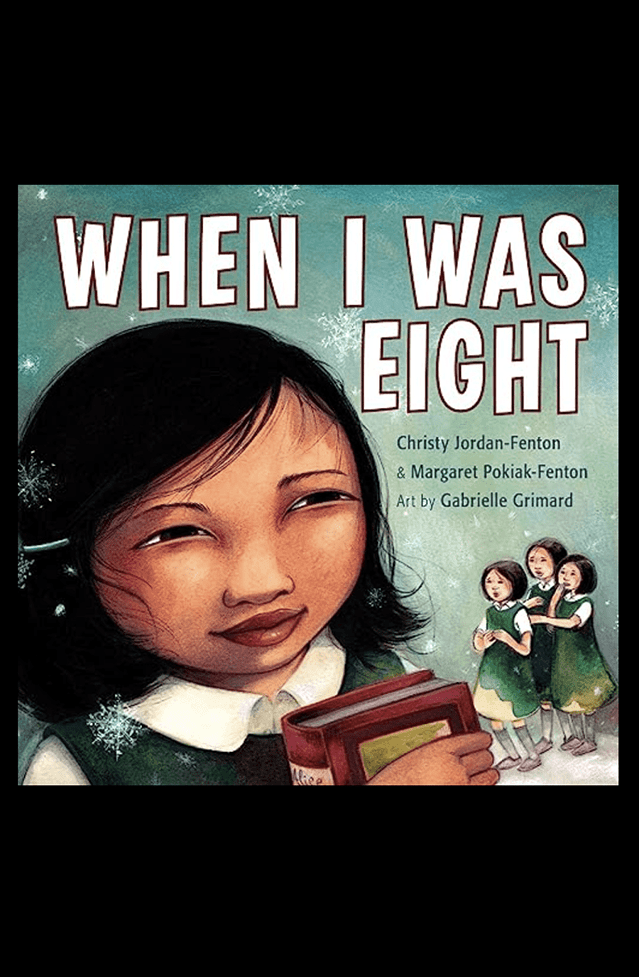 Book cover of "when i was eight" featuring a young girl holding a book with two other girls in the background.