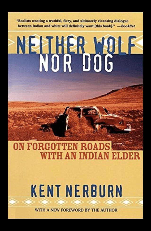 Book cover of "neither wolf nor dog" by kent nerburn featuring a deserted road with a rusty car and barren landscape under a blue sky.