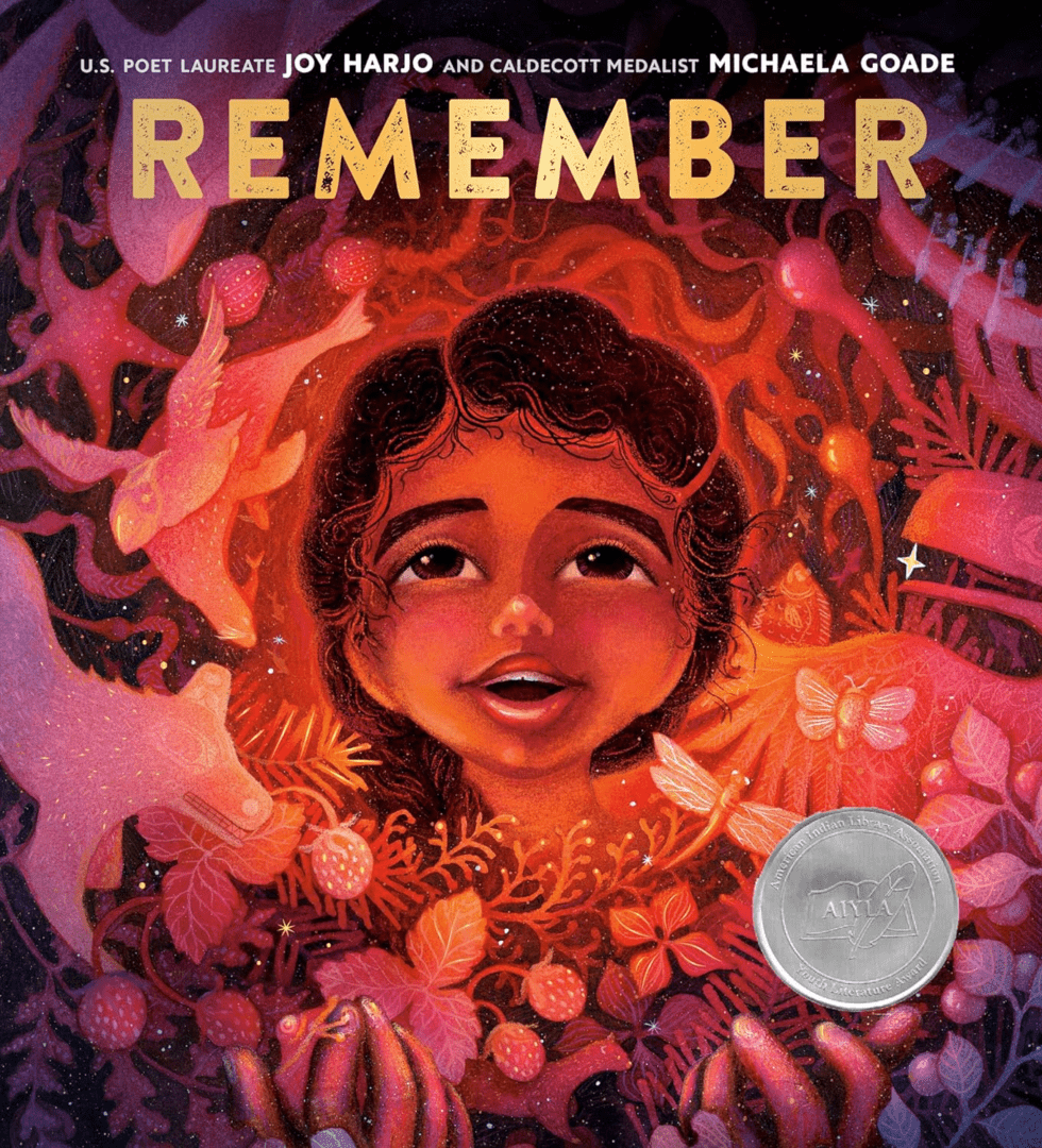 Illustrated book cover titled "remember" featuring a joyful child surrounded by vibrant, nature-themed artwork and a silver medal emblem.